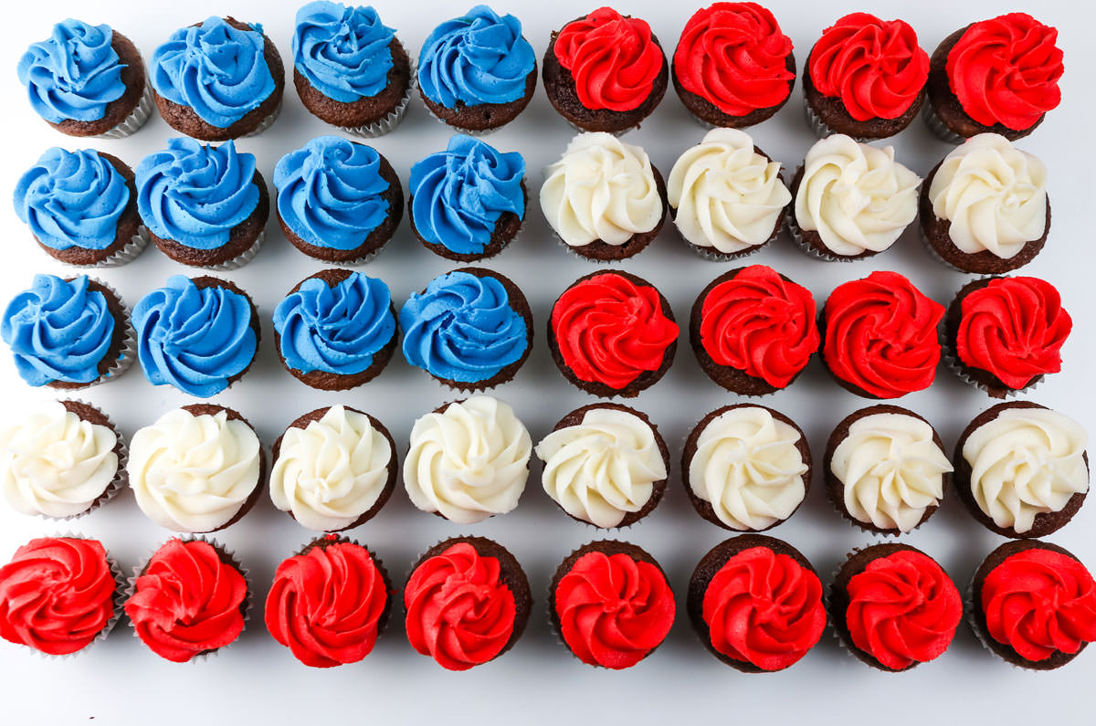 Closeup on forty Red White and Blue Mini Cupcakes arranged in a shape of an American Flag on a white table.