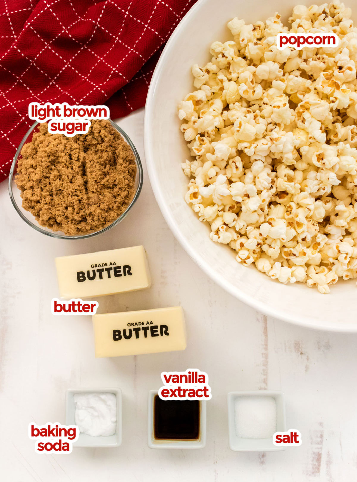 All the ingredients you will need to make Easy Homemade Caramel Corn including popcorn, butter, brown sugar, vanilla extract, salt and baking soda.