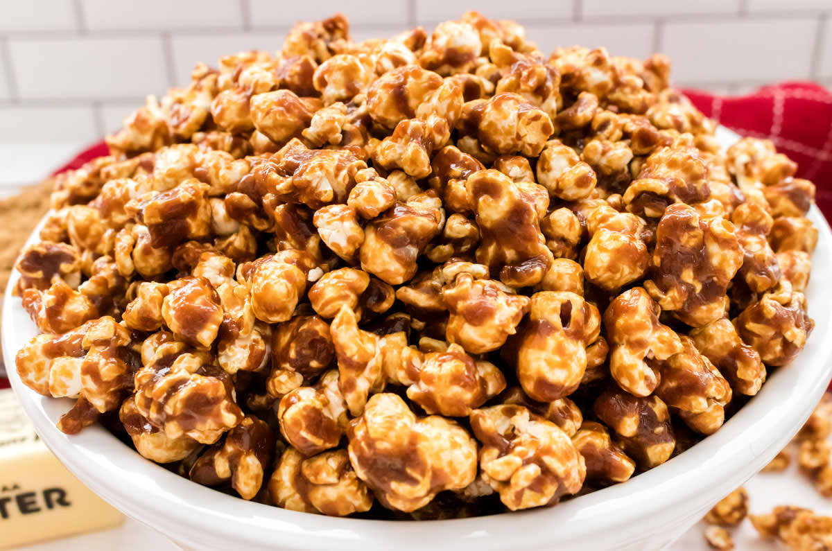 Closeup on a white serving bowl filled with a batch of Easy Homemade Caramel Corn.