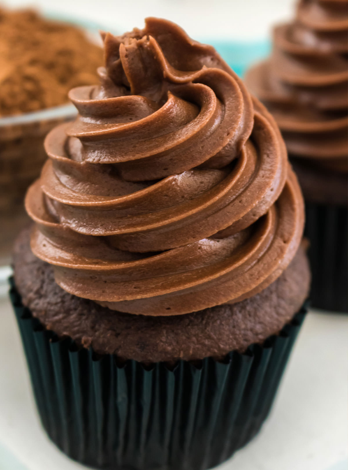 Closeup on a chocolate cupcake topped with a swirl of The Best Chocolate Cream Cheese Frosting.
