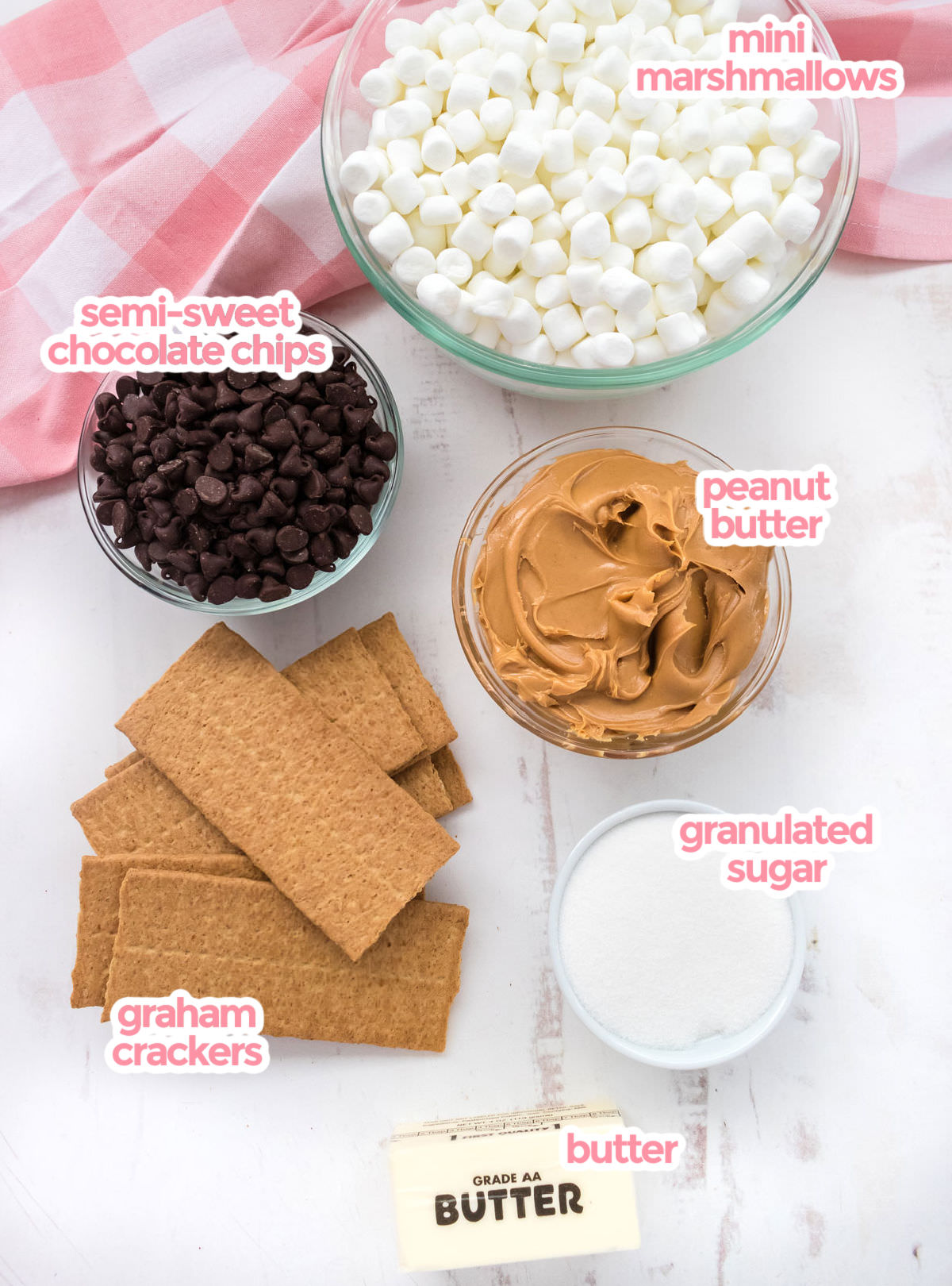 All the ingredients you will need to make Chocolate Marshmallow Bars including Mini Marshmallows, Chocolate Chips, Peanut Butter, Graham Crackers, Butter and Sugar.