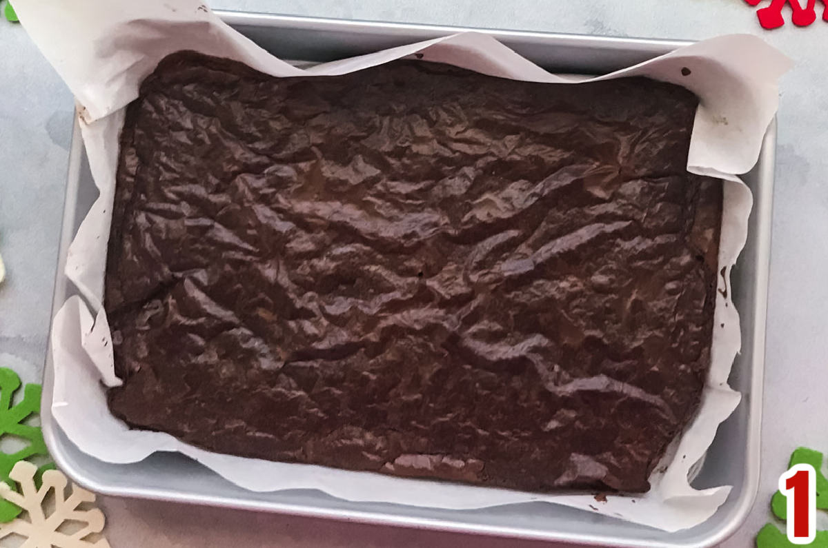 A pan of brownies in a metal 9x13" pan laying on a grey table.