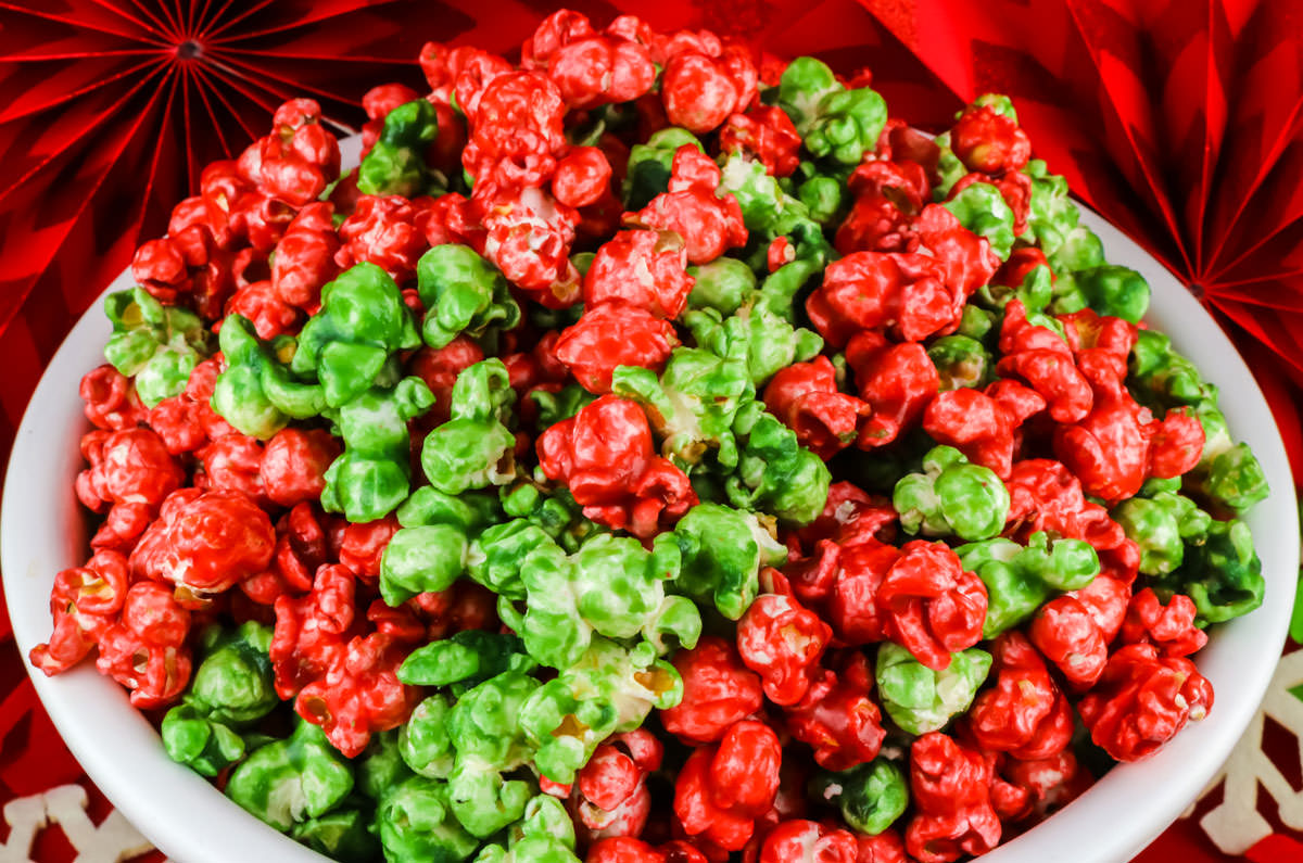 Closeup on a white serving bowl filed with Red and Green Christmas Caramel Corn.