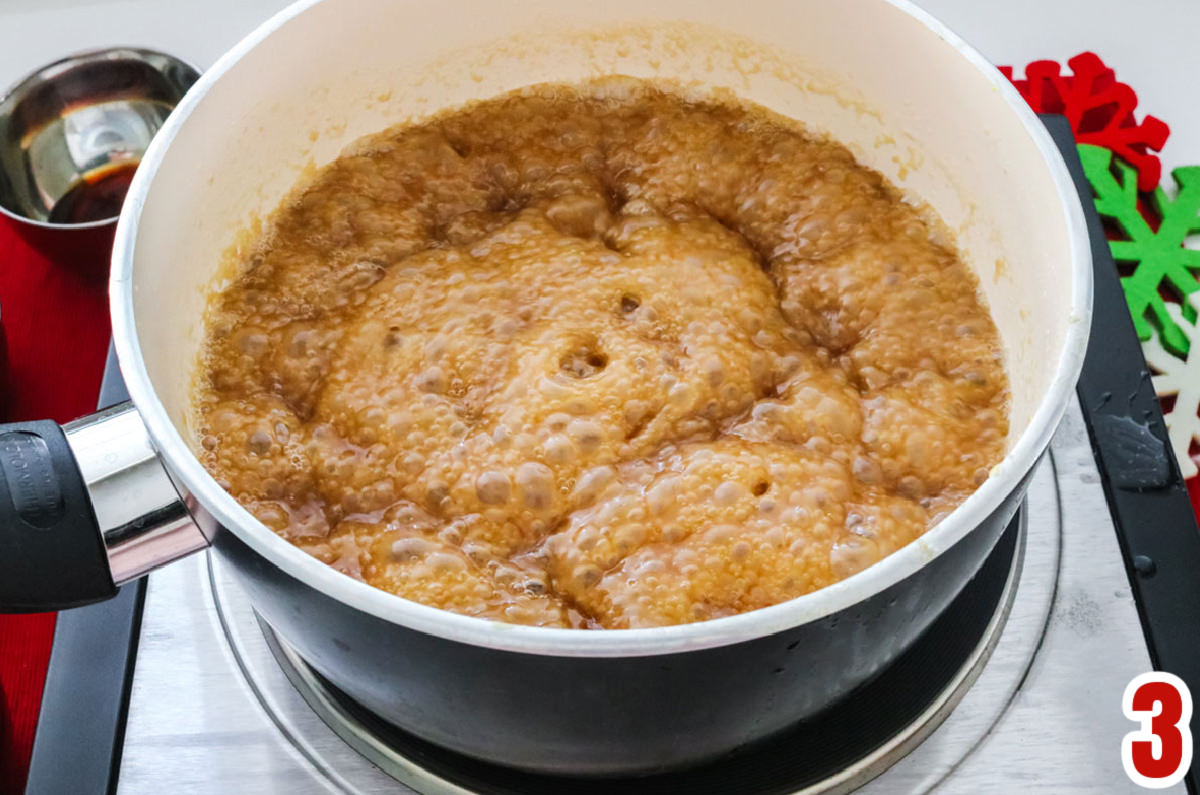 Closeup on a sauce pan with the caramel corn mixture boiling on a hot plate.