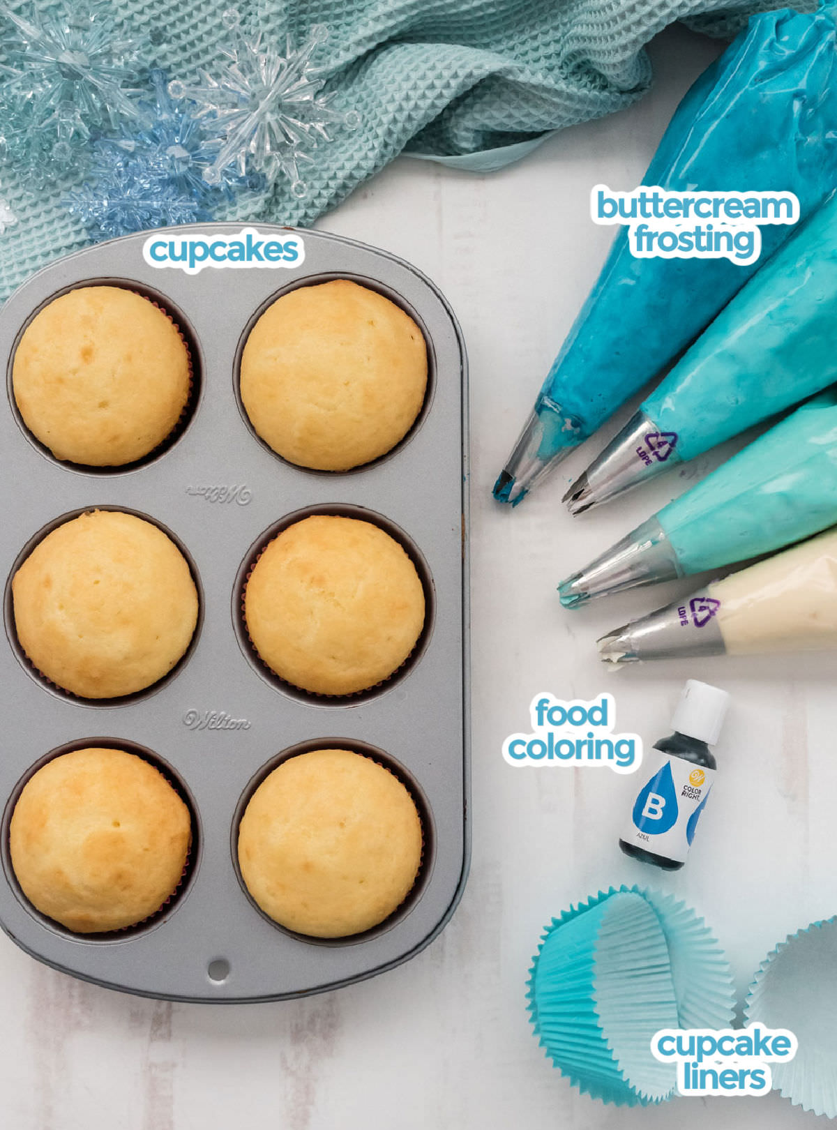All the ingredients you will need to make Frozen Ombre Swirl Cupcakes including vanilla cupcakes, buttercream frosting, food coloring and cupcake liners.