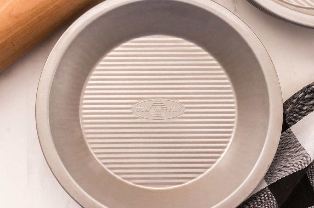 Picture of a metal pie plate and a rolling pin.