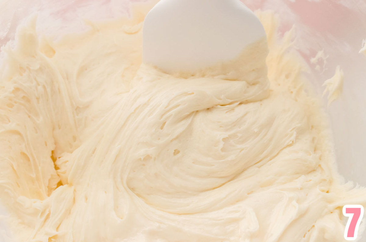 Closeup on a glass bowl filled with a batch of The Best Marshmallow Buttercream Frosting and a white spatula.