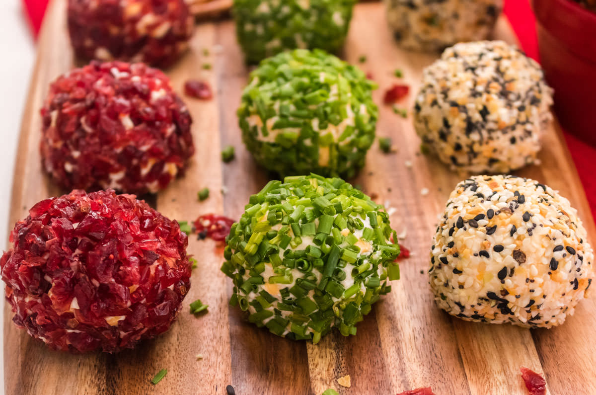 Three flavors of Cheese Ball Bites sitting on a wooden platter.