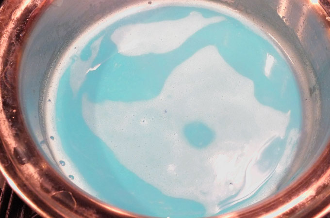 Add food coloring to milk in saucepan