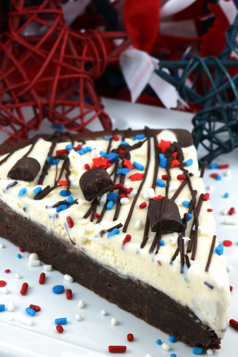 Patriotic Ice Cream Cookie Pizza - a fun and yummy dessert pizza made with chocolate cookie and vanilla ice cream topped with gorgeous red white and blue sprinkles. This Fourth of July dessert will wow the guests at your 4th of July party. Pin this 4th of July treat for later and follow us for more great 4th of July Food ideas. #4thofJuly #fourthofjuly #4thofJulyTreats #4thofJulyDesserts #4thofJulyFoodIdeas