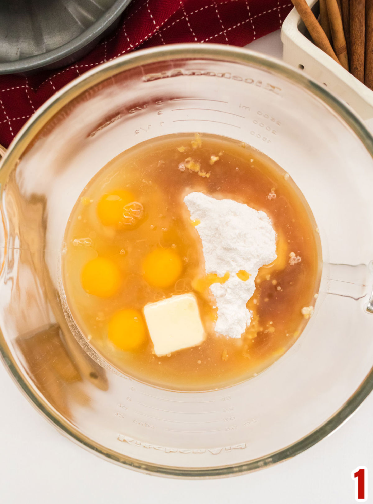 Closeup on a glass mixing bowl filled with the ingredients to make the cake batter.