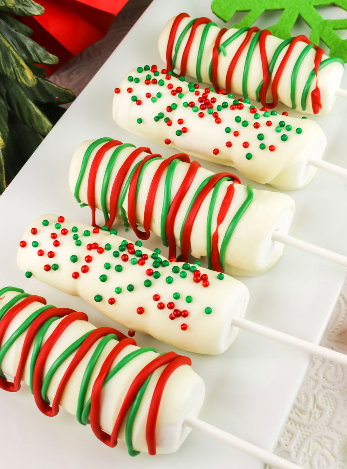 Closeup on a white serving platter filled with five White Chocolate Marshmallow Pops.